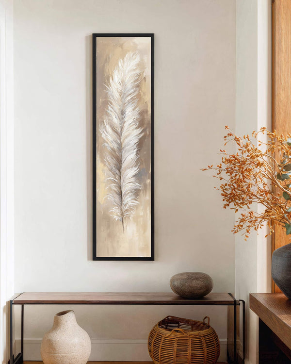 This narrow vertical painting print features an impressionistic white feather in neutral tones, shown in a black floater frame on a white wall above a minimalist wood console table.