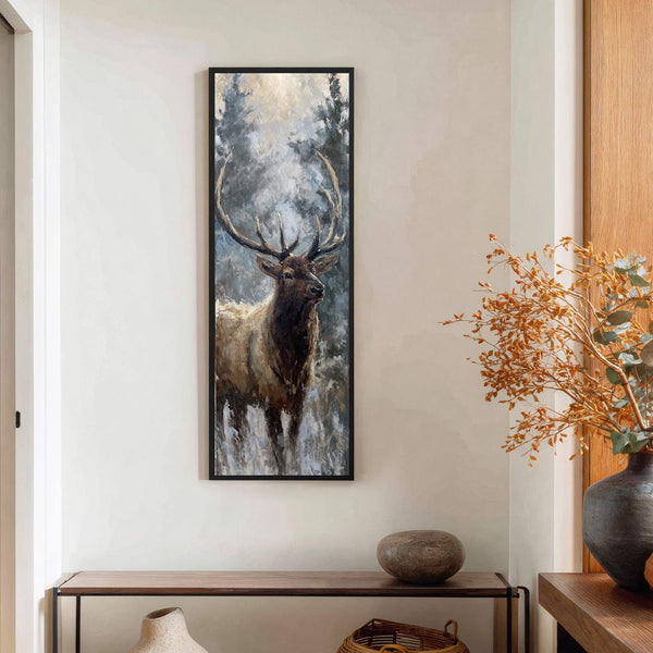 This vertical canvas wall art depicts a stag with large antlers in a moody, impressionistic style with a muted palette, hanging above a wooden console table against a light wall.