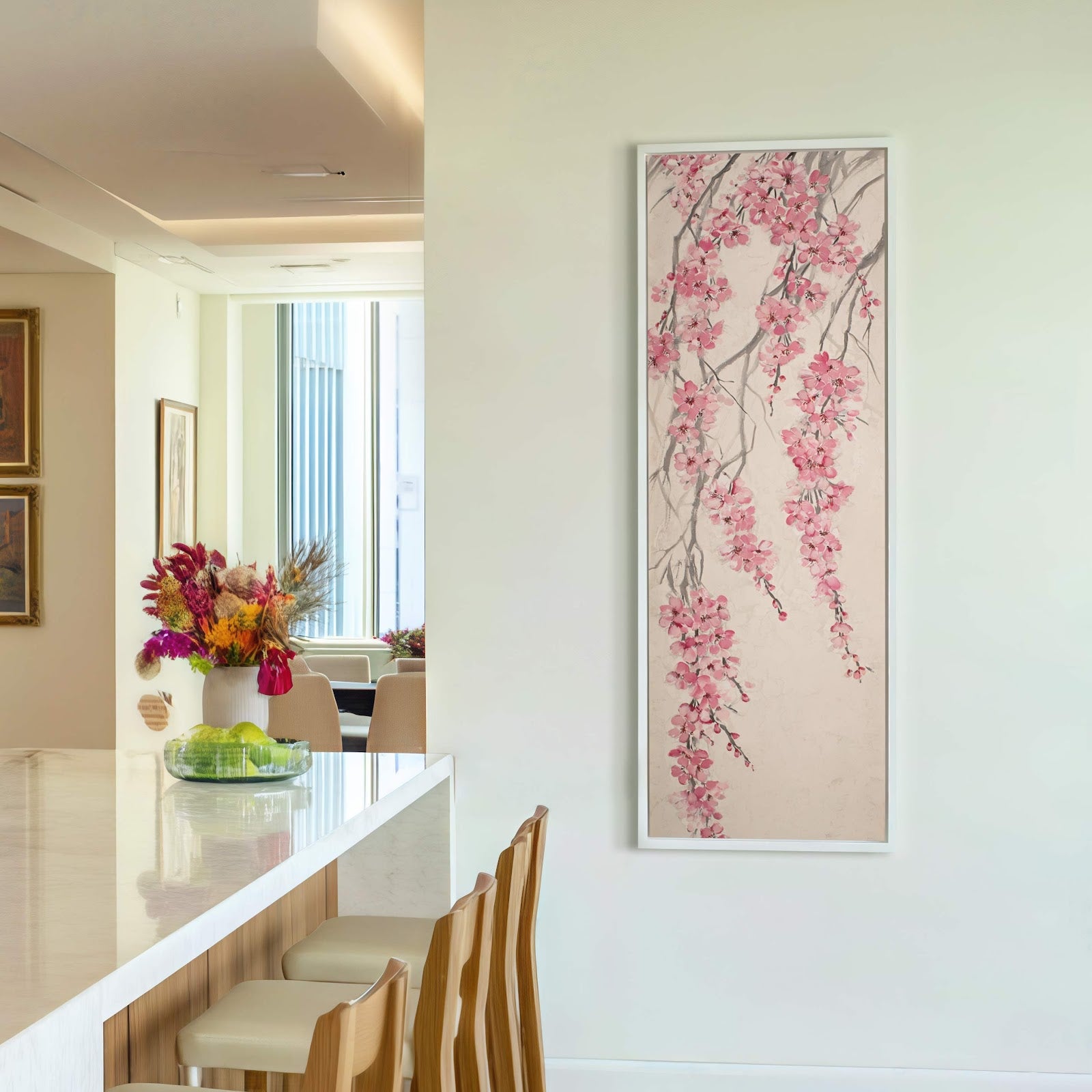 This vertical canvas wall art features a delicate painting of pink cherry blossoms on a light background, set against a plain white wall above bar stools.