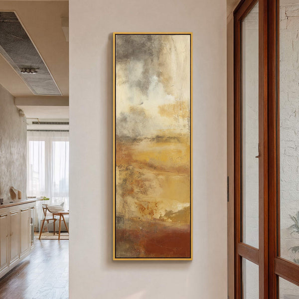This vertical abstract canvas print features a palette of warm earthy tones with brown, yellow, and gray textures. It is displayed on a light-colored wall in what appears to be.