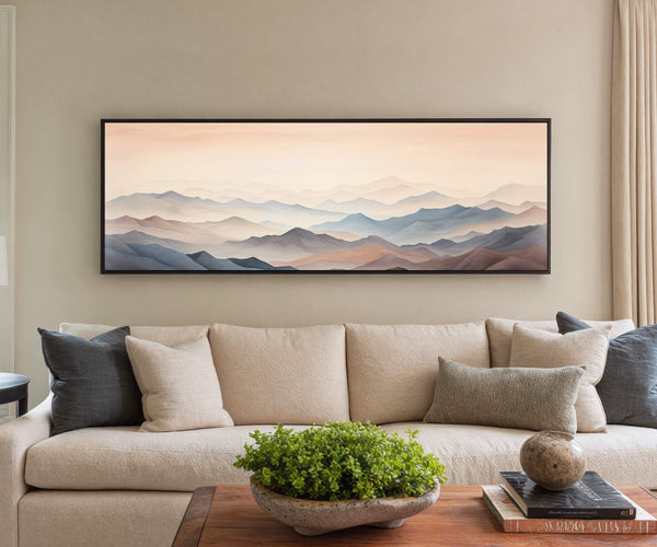Framed abstract mountain landscape canvas wall art displayed above a beige sofa in a modern living room with neutral decor