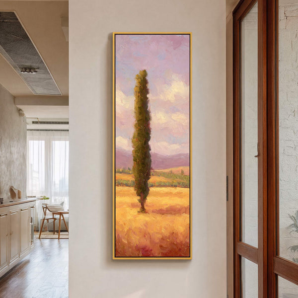This vertical oil painting print features a single cypress tree in a golden field with a lavender sky, presented in a gold floater frame against a neutral wall.