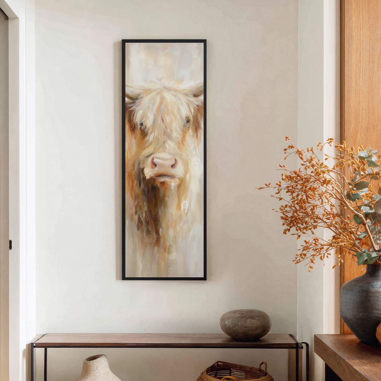 This vertical, impressionist painting print features a Highland cow portrait in warm, earthy tones, framed in black, and displayed above a wooden console table against a white wall.