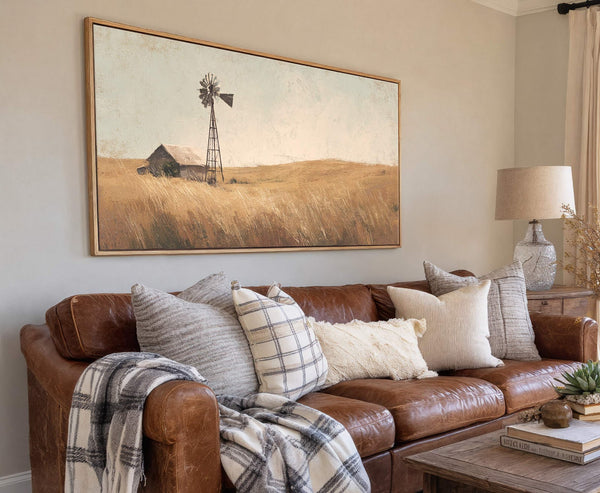 This horizontal, rustic-style canvas wall art print features a sepia-toned landscape with a windmill and barn, set against a pale blue sky and golden field, framed in a natural wood.