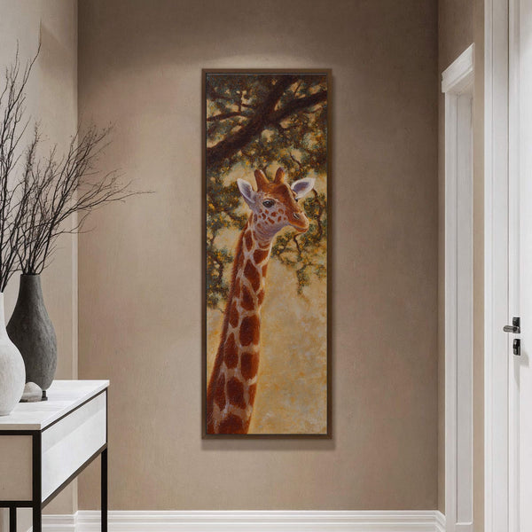 This vertical canvas wall art features a detailed, textural painting of a giraffe's head against a backdrop of tree foliage in warm, earthy tones. It is framed in a dark.