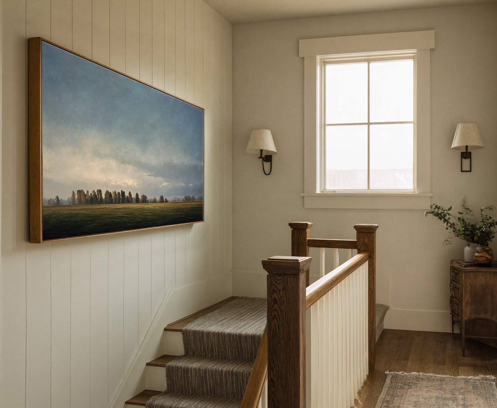 This horizontal canvas print features a landscape with a field and trees under a cloudy sky, rendered in muted greens and blues. It is framed in natural wood and hangs.