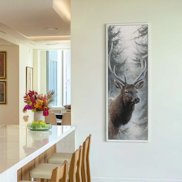 This vertical, unframed canvas wall art depicts a realistic elk in a misty forest setting with a muted gray and blue palette, displayed on a light-colored wall in a room.