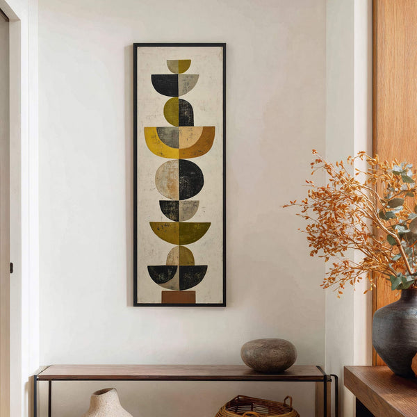 This vertical canvas wall art features a mid-century modern abstract design with a palette of muted yellow, olive green, black, and beige, displayed on a textured white drywall next to.