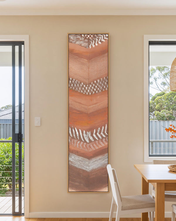 Vertical canvas wall art in interior setting.