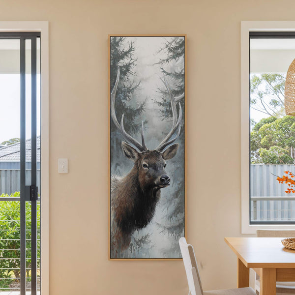 This vertical canvas print features a realistic deer artwork in a muted palette, set against a foggy forest background, displayed on a neutral wall next to a window and a.