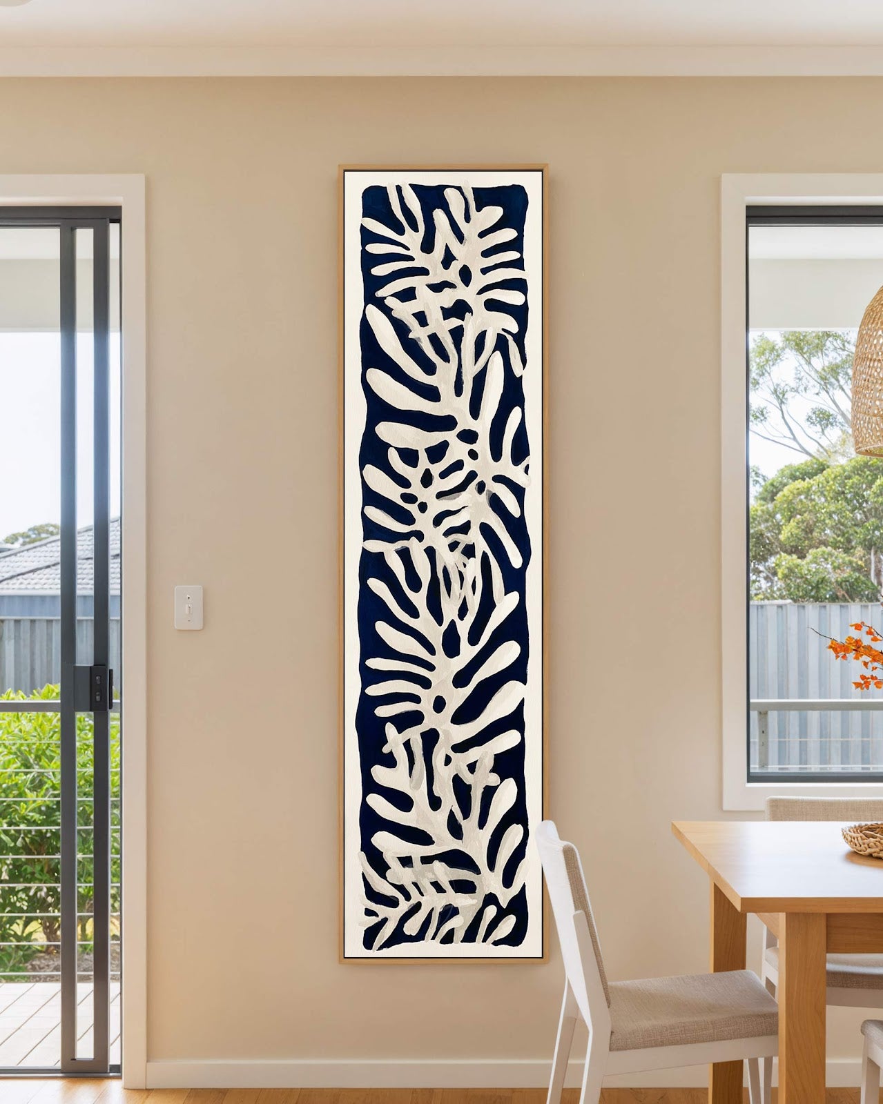 Vertical canvas wall art in interior setting.