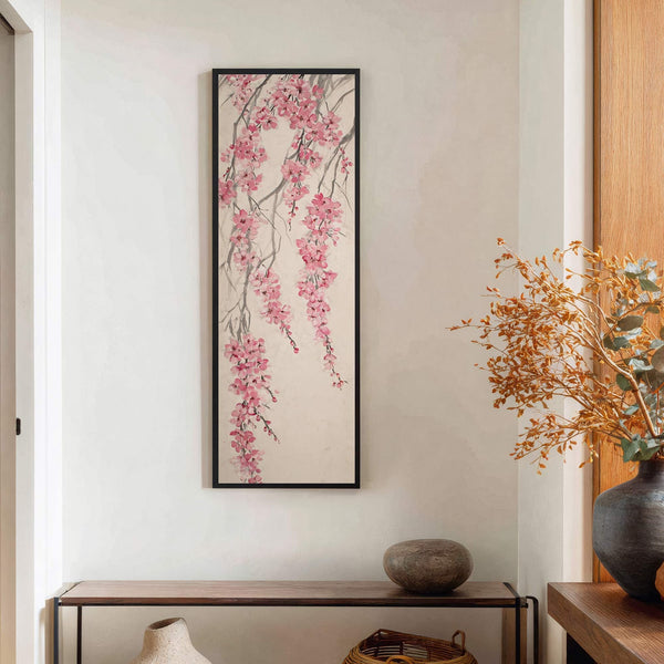 This vertical, framed canvas wall art features a traditional East Asian style painting of pink cherry blossoms on a textured, neutral background, hung above a narrow wooden console table on.