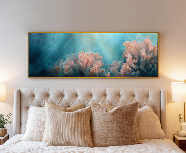 Framed pink coral reef canvas wall art hung above a tufted beige headboard in a cozy bedroom with neutral decor and warm lighting