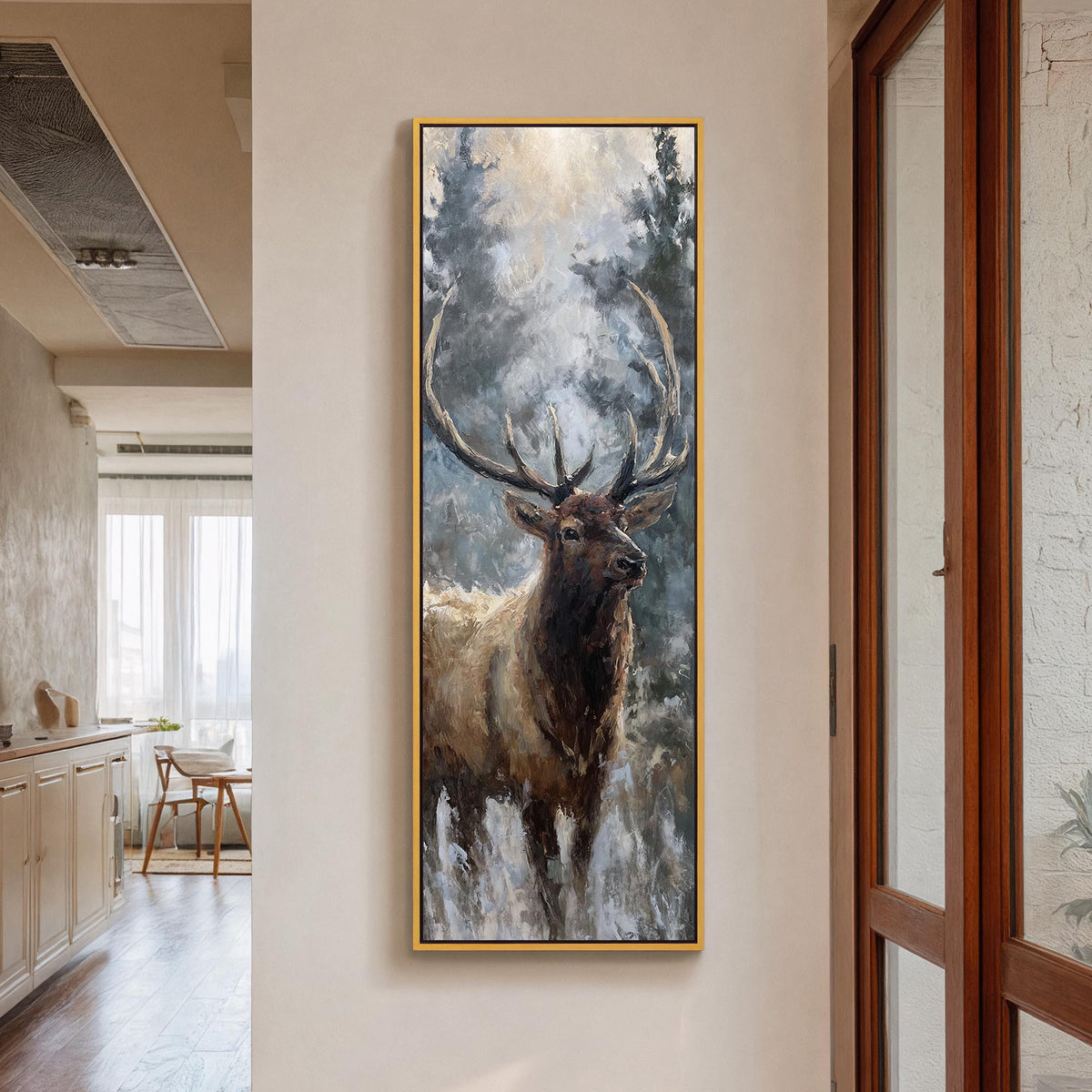 Canvas print of an elk among gray-blue forest trees in a gold floater frame beside glass doors.