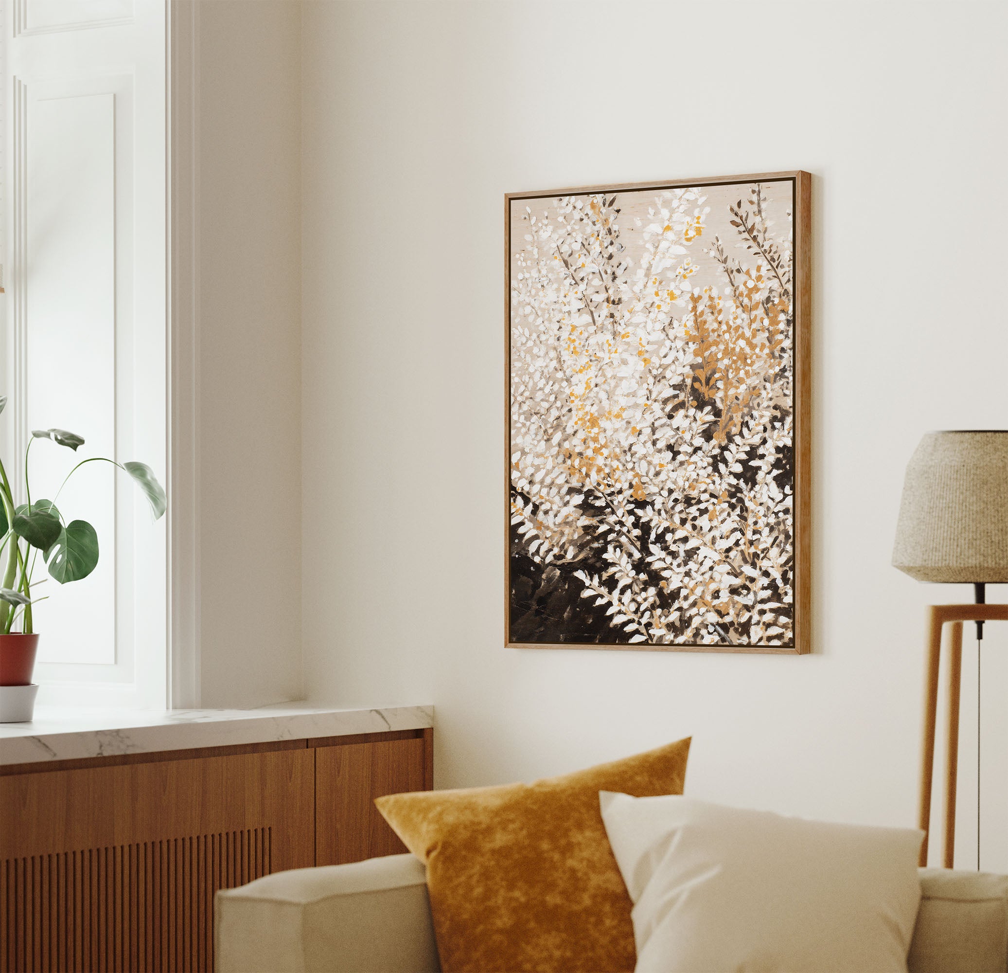 Abstract botanical wall art featuring white wildflowers with gold accents on gradient beige to charcoal background, displayed in modern living room with mid-century furniture
