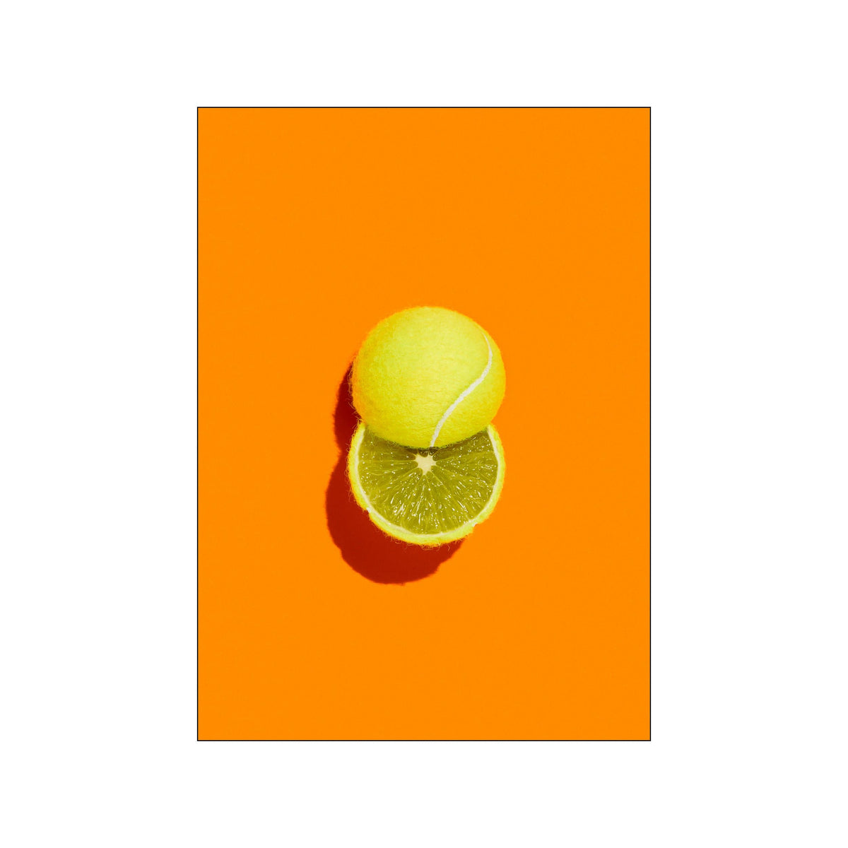 A tennis ball stacked on a lime slice against a vivid orange background
